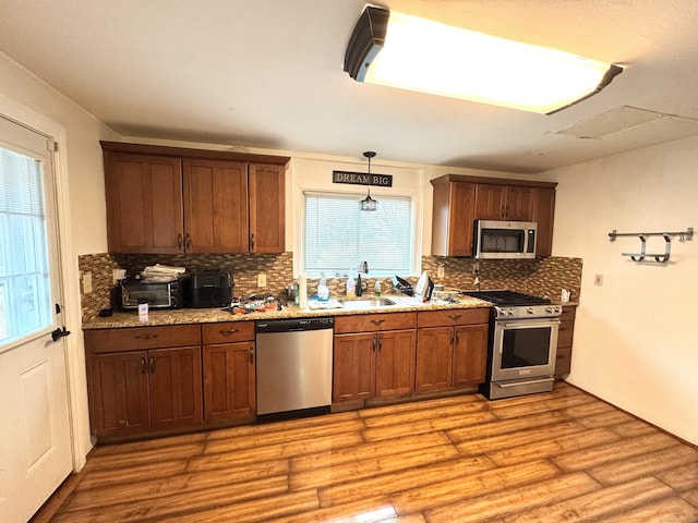 136 Oberlin Rd, Hamden, CT 06514 - kitchen featuring tasteful backsplash, light wood-type flooring, appliances with stainless steel finishes, and a sink
