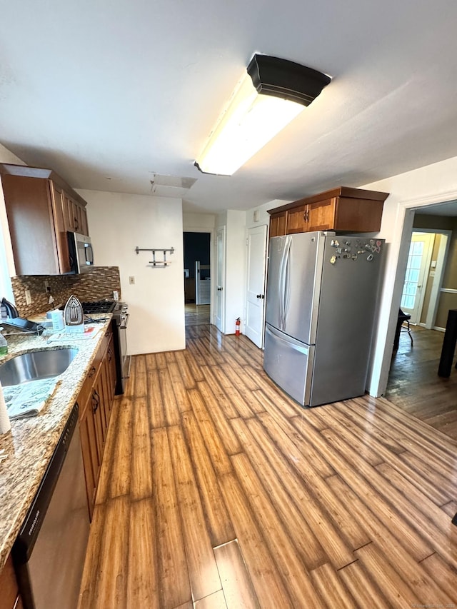 136 Oberlin Rd, Hamden, CT 06514 - kitchen with light stone counters, backsplash, a sink, light wood-style floors, and appliances with stainless steel finishes