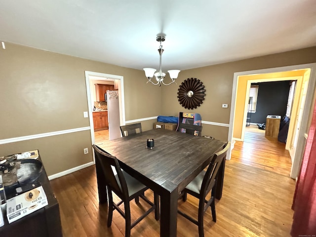 136 Oberlin Rd, Hamden, CT 06514 - dining space with light wood-type flooring, baseboards, and a notable chandelier