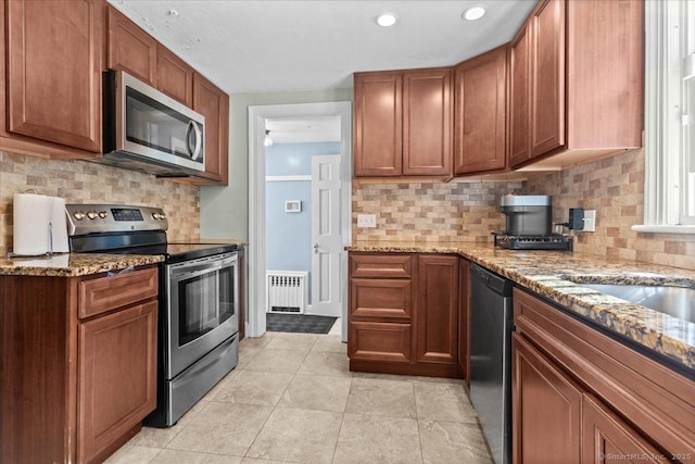 116 Gaylord Dr, Waterbury, CT 06708 - kitchen with stainless steel appliances, tasteful backsplash, radiator heating unit, light stone countertops, and light tile patterned floors