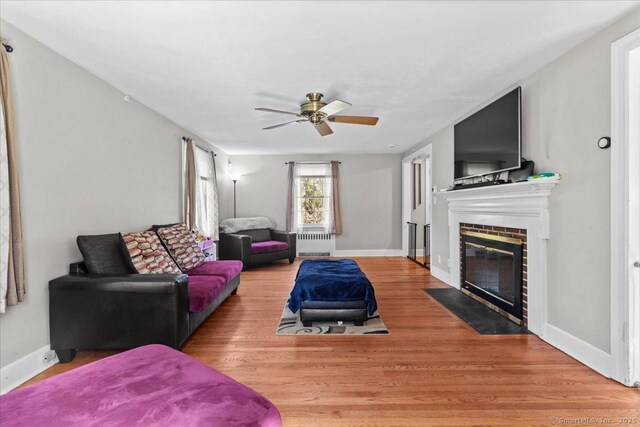116 Gaylord Dr, Waterbury, CT 06708 - living room with wood finished floors, a brick fireplace, a ceiling fan, and baseboards