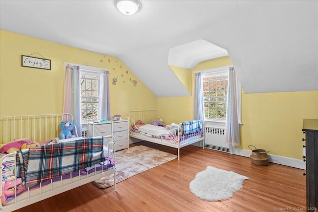 116 Gaylord Dr, Waterbury, CT 06708 - bedroom with lofted ceiling, radiator heating unit, wood finished floors, and multiple windows