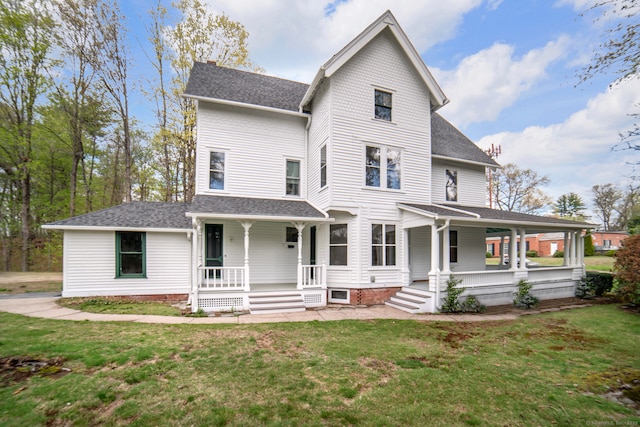 view of front of home with a front lawn, a shingled roof, and covered porch