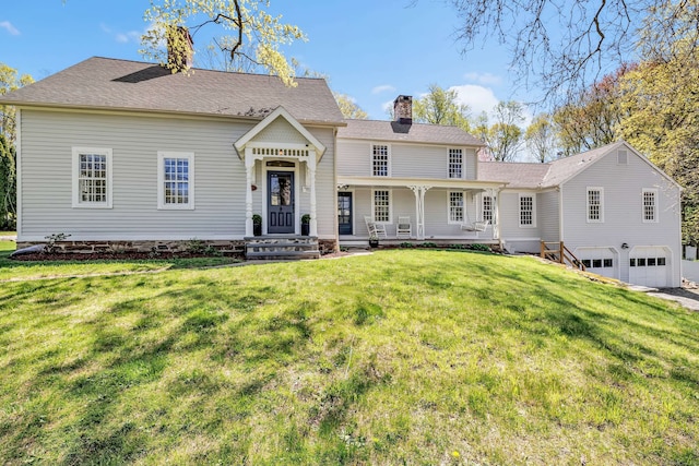 view of front of property featuring a garage, a chimney, and a front lawn