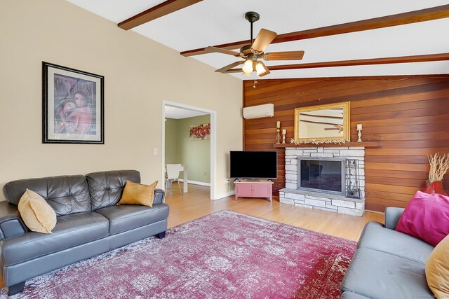 living room featuring a fireplace, ceiling fan, wood walls, an AC wall unit, and wood finished floors