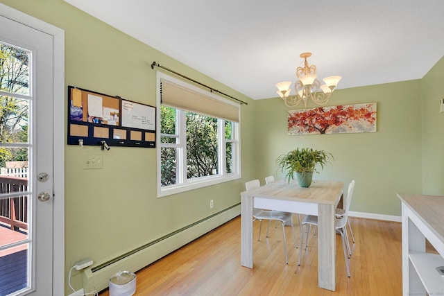dining area featuring a chandelier, light wood-style flooring, baseboard heating, and baseboards
