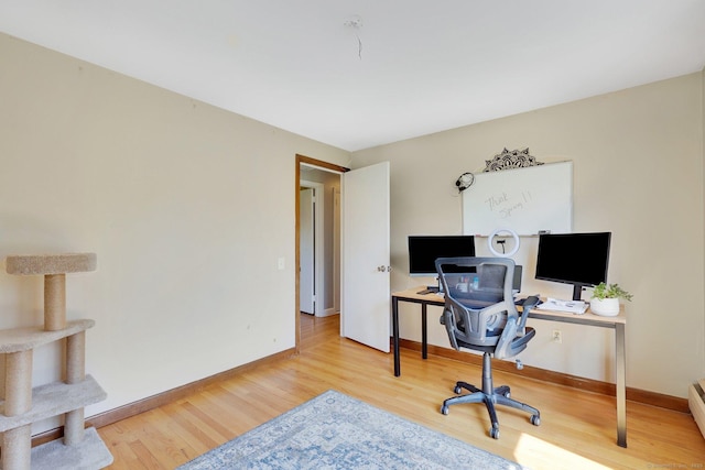 office space featuring baseboards and wood finished floors