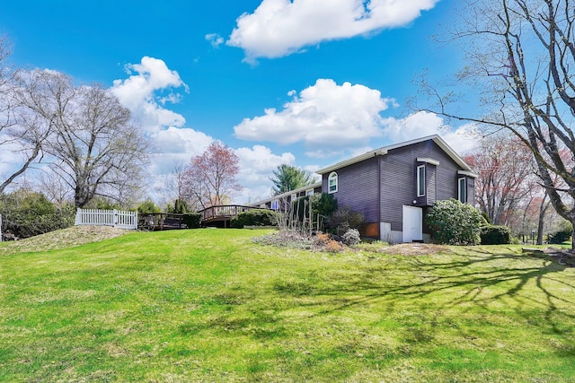 view of yard featuring a wooden deck and fence