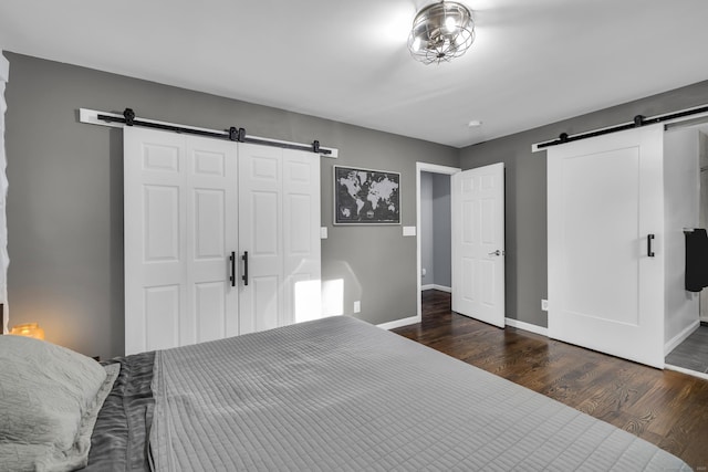11 Botte Dr, West Haven, CT 06516 - bedroom with a barn door, baseboards, a closet, and dark wood-style floors