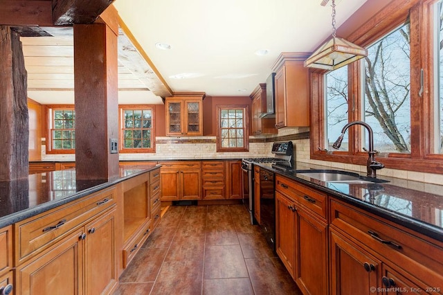 15 Fox Den Rd, Danbury, CT 06811 - kitchen with dark stone counters, tasteful backsplash, a sink, brown cabinetry, and gas range