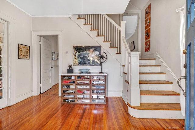 stairway with hardwood / wood-style flooring, crown molding, and baseboards