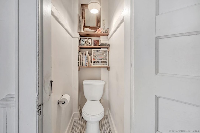 bathroom with toilet, tile patterned flooring, and baseboards