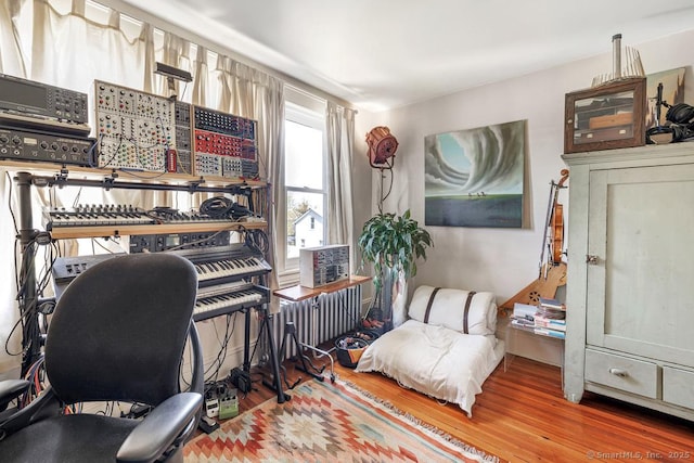 home office with radiator and wood finished floors