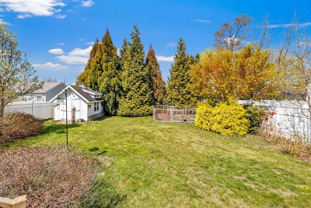 view of yard featuring an outbuilding, a garden, and fence