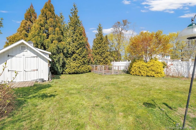 view of yard featuring fence, an outdoor structure, and a shed