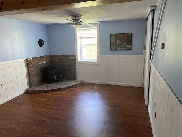 150 Mathew Rd, Winchester, CT 06098 - unfurnished living room featuring a wainscoted wall, a ceiling fan, a wood stove, and wood finished floors