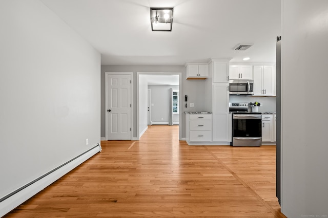 kitchen with visible vents, a baseboard radiator, white cabinets, light wood finished floors, and stainless steel appliances