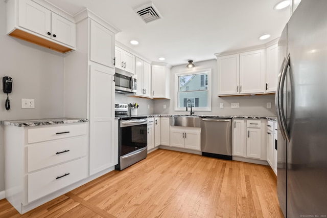 kitchen with a sink, appliances with stainless steel finishes, recessed lighting, and visible vents