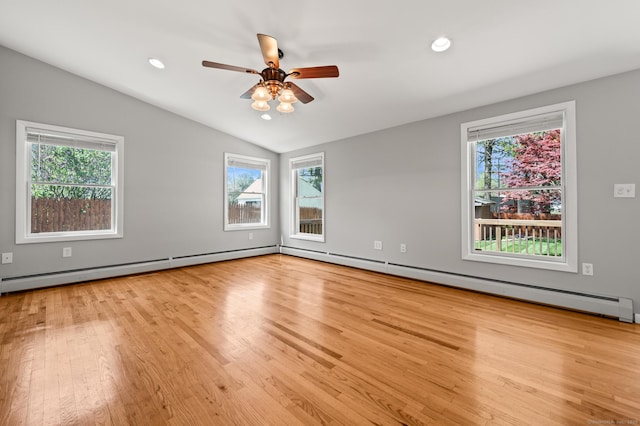 spare room with plenty of natural light, wood finished floors, and lofted ceiling