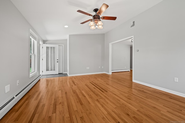 empty room with a ceiling fan, visible vents, baseboard heating, and light wood-style floors