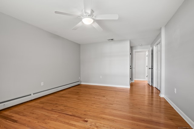 empty room featuring ceiling fan, visible vents, baseboards, a baseboard heating unit, and light wood-style floors
