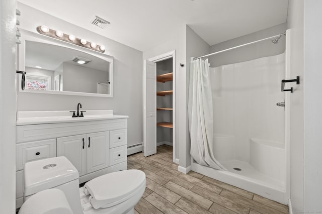 bathroom with a baseboard heating unit, wood finish floors, toilet, and a shower stall