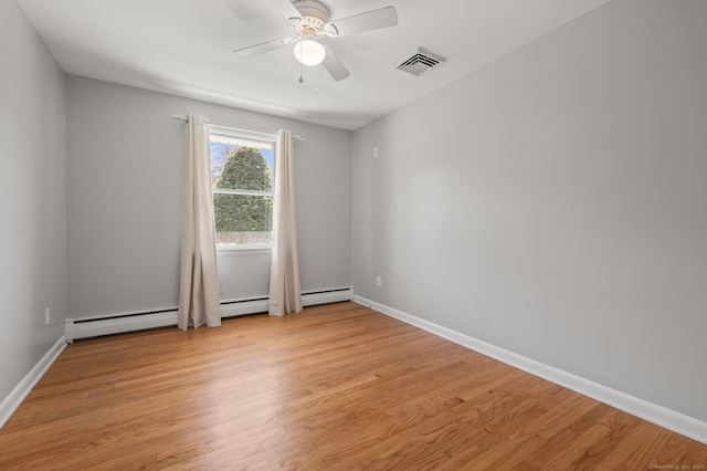 spare room featuring baseboards, ceiling fan, light wood finished floors, and visible vents
