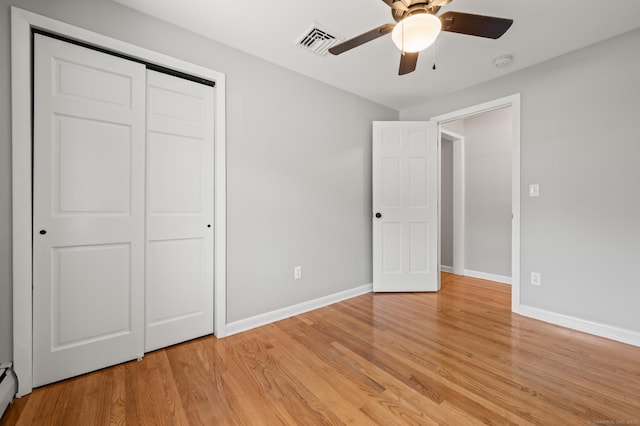 unfurnished bedroom with visible vents, light wood finished floors, baseboards, and a closet