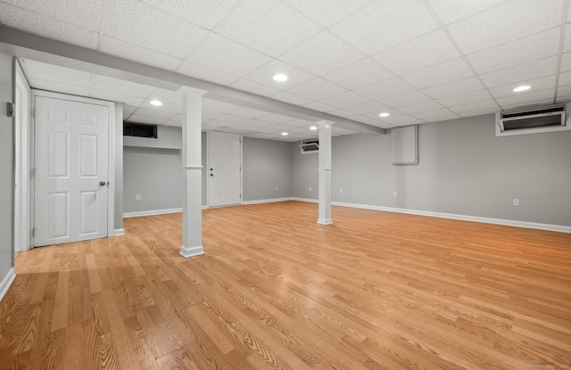 finished basement featuring baseboards, recessed lighting, light wood-style flooring, and a paneled ceiling