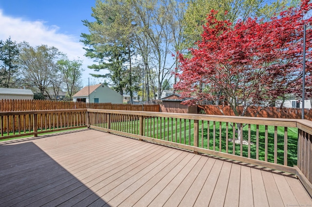 wooden terrace with a fenced backyard and a lawn