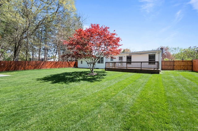 view of yard with a fenced backyard and a wooden deck