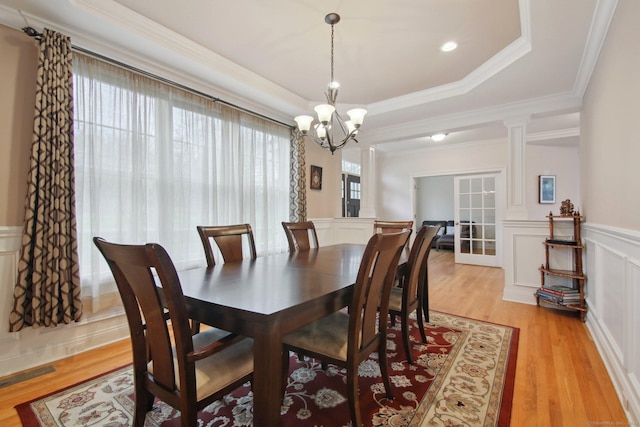 96 Damascus Rd, Branford, CT 06405 - dining room featuring a wainscoted wall, an inviting chandelier, a raised ceiling, ornamental molding, and light wood-style floors