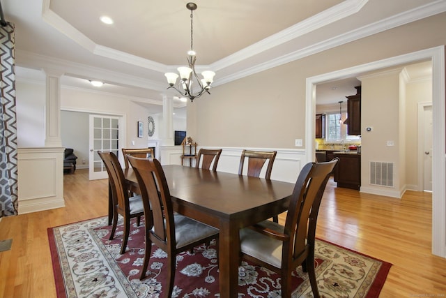 96 Damascus Rd, Branford, CT 06405 - dining room with crown molding, light wood-style flooring, a raised ceiling, visible vents, and ornate columns