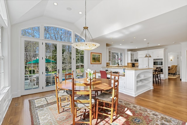dining area featuring recessed lighting, visible vents, vaulted ceiling, and light wood-style floors