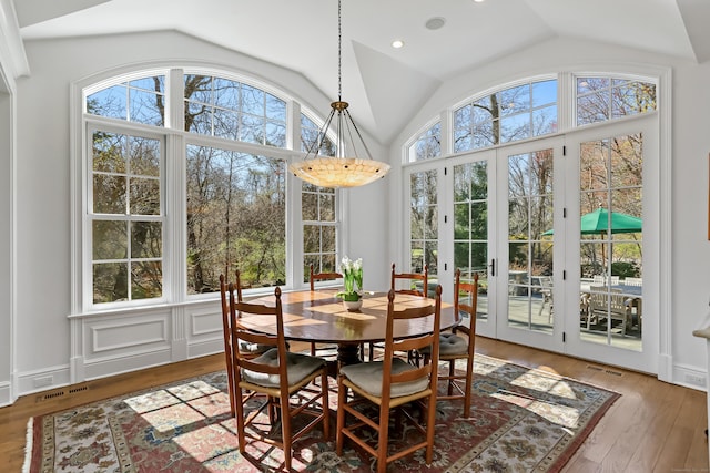 dining room with visible vents, hardwood / wood-style flooring, recessed lighting, and vaulted ceiling