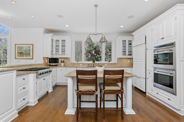 kitchen featuring white cabinetry, stainless steel appliances, dark wood-style floors, and backsplash