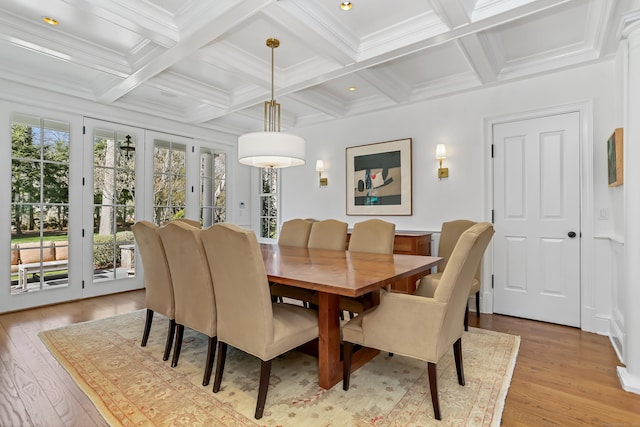dining room featuring beamed ceiling, light wood-style floors, crown molding, and coffered ceiling