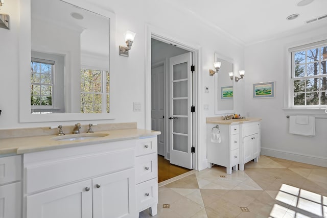 full bath featuring a sink, tile patterned floors, crown molding, two vanities, and visible vents