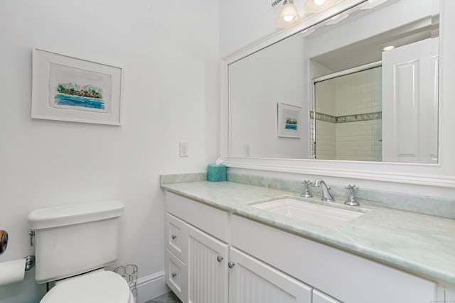 bathroom with baseboards, a tile shower, toilet, and vanity