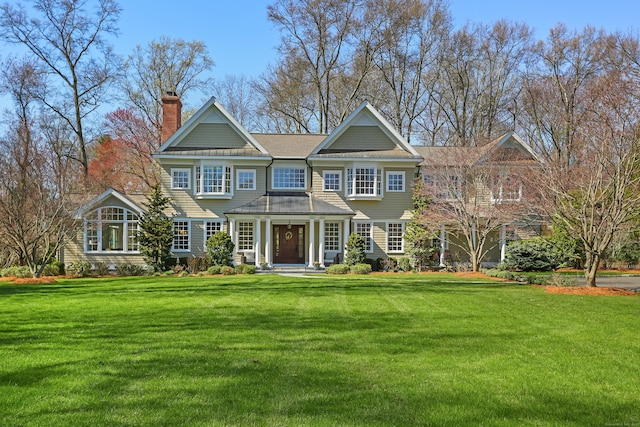 view of front facade featuring a chimney and a front yard
