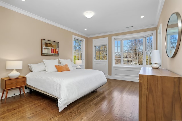 bedroom featuring dark wood-style flooring, visible vents, crown molding, and recessed lighting