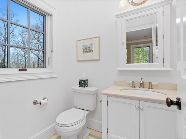 bathroom featuring vanity, toilet, and baseboards