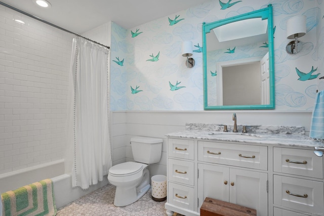 full bathroom with a wainscoted wall, shower / bath combo with shower curtain, toilet, recessed lighting, and vanity