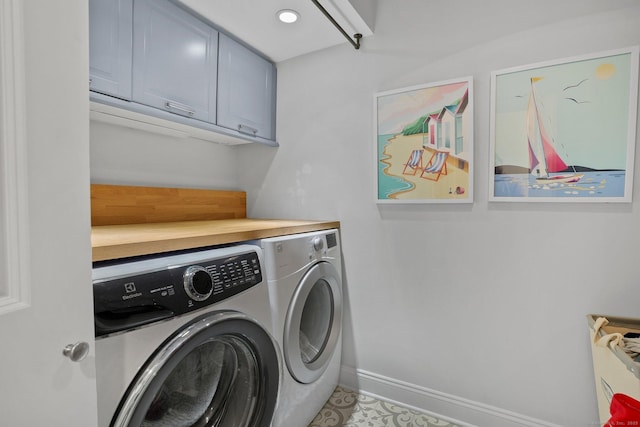 laundry room featuring baseboards, recessed lighting, cabinet space, and washing machine and clothes dryer