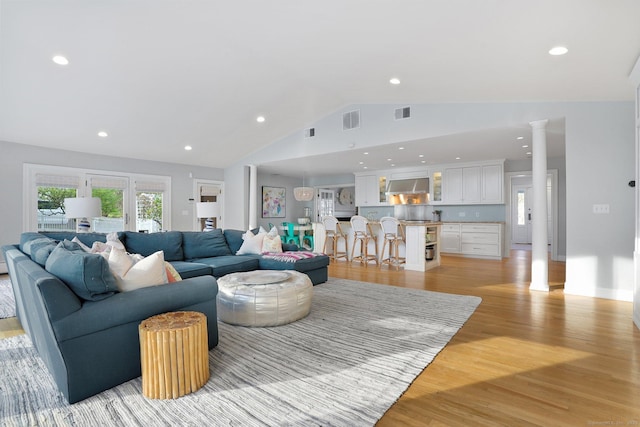 living room with visible vents, light wood-type flooring, lofted ceiling, and recessed lighting
