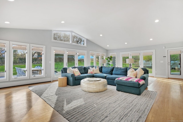 living room featuring recessed lighting, light wood-style flooring, a baseboard heating unit, high vaulted ceiling, and french doors