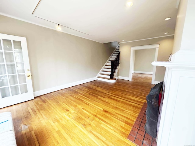 187 W Park Ave, New Haven, CT 06511 - unfurnished living room with baseboards, stairway, hardwood / wood-style flooring, and radiator heating unit