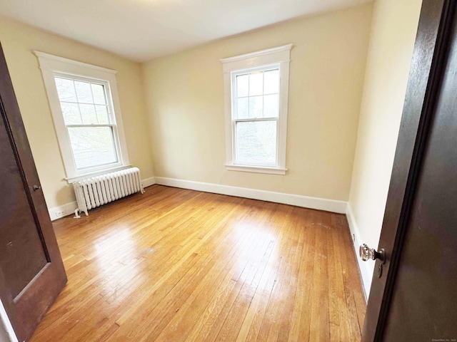 187 W Park Ave, New Haven, CT 06511 - empty room with radiator heating unit, light wood-style flooring, and plenty of natural light