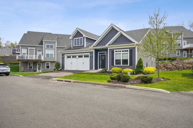view of front of property featuring aphalt driveway, a garage, and a front yard