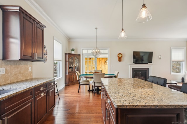 kitchen with backsplash, a wealth of natural light, ornamental molding, and dark wood-type flooring